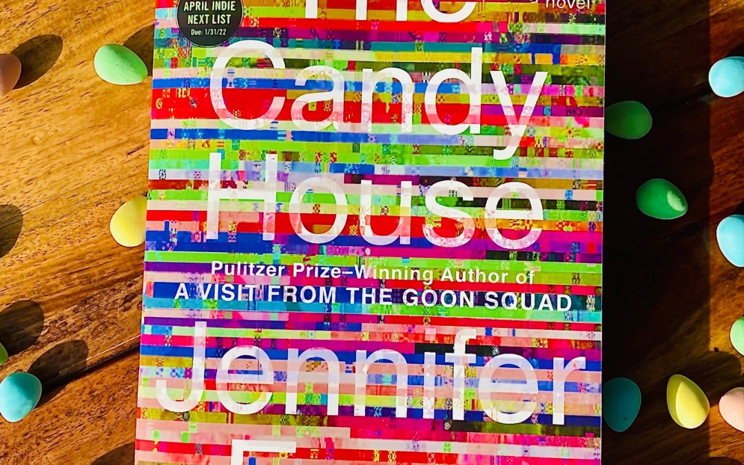 The Candy House by Jennifer Egan book with small multicoloured candies surrounding the book on a wooden background