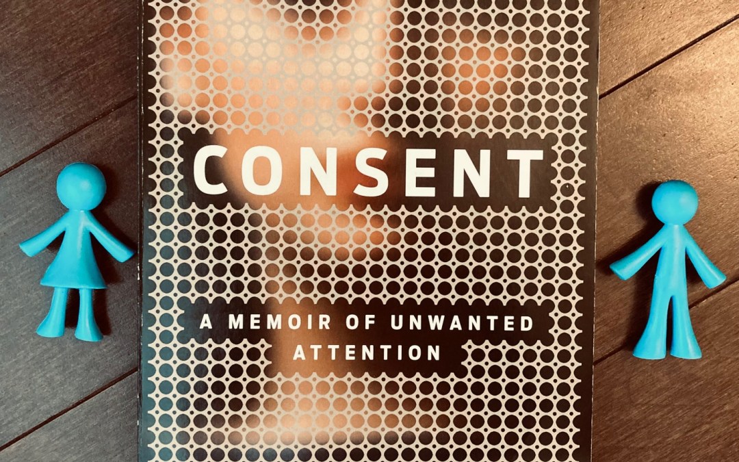 Consent by Donna Freitas book with a blue plastic girl and boy figure on either side of the book, lying on top of a wooden background