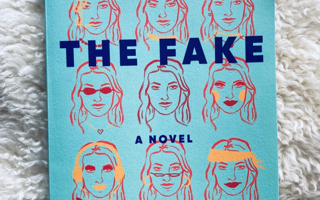 The Fake by Zoe Whittall book pictured on a white shag background with a pair of black plastic glasses frames above the book