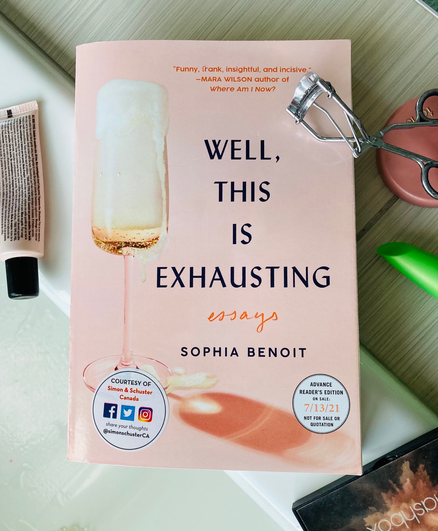 Well, This is Exhausting by Sophia Benoit book pictured with containers of makeup scattered around it