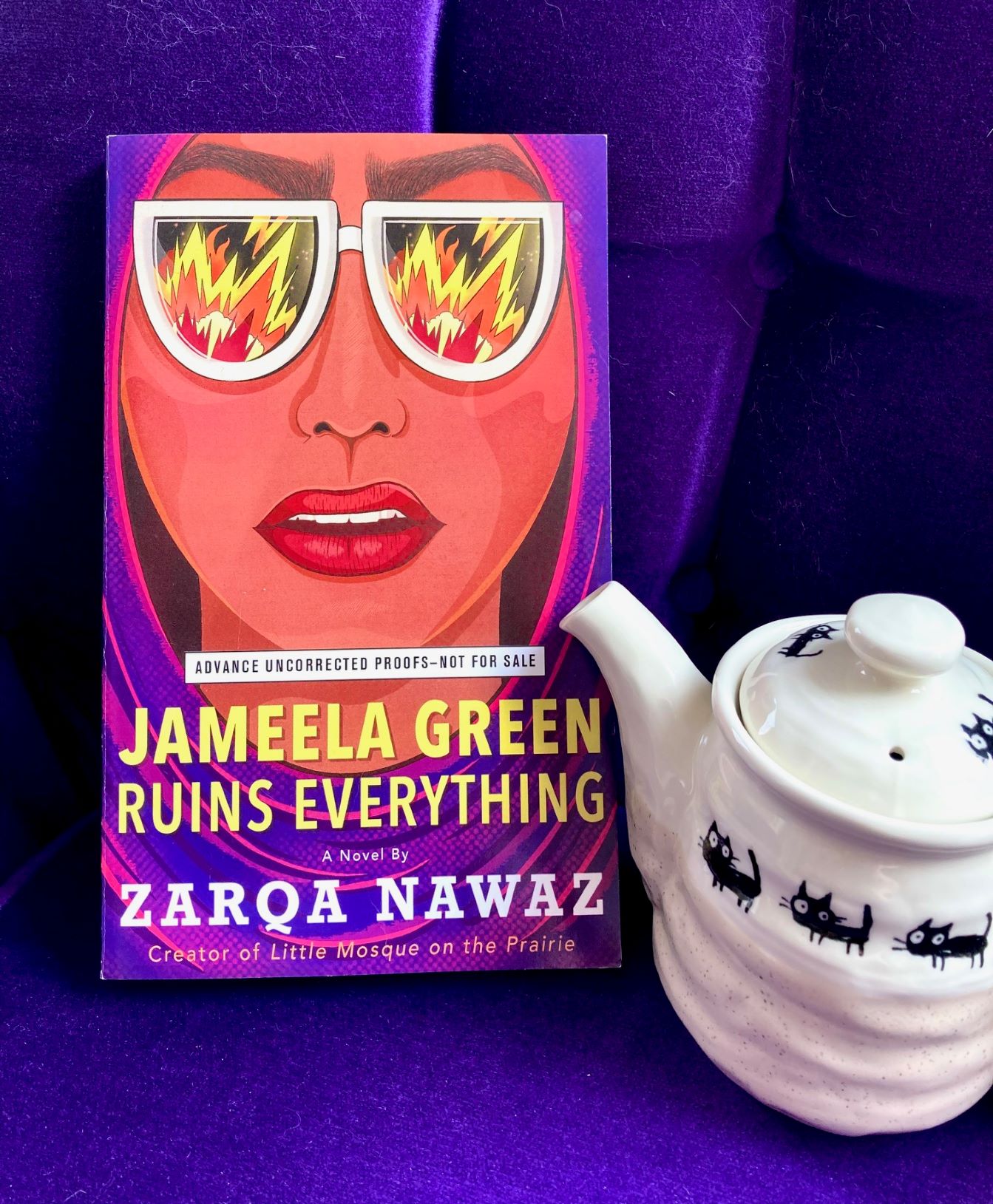 Jameela Green Ruins Everything by Zarqa Nawaz book pictured on a purple background with a small white teapot in front of the book