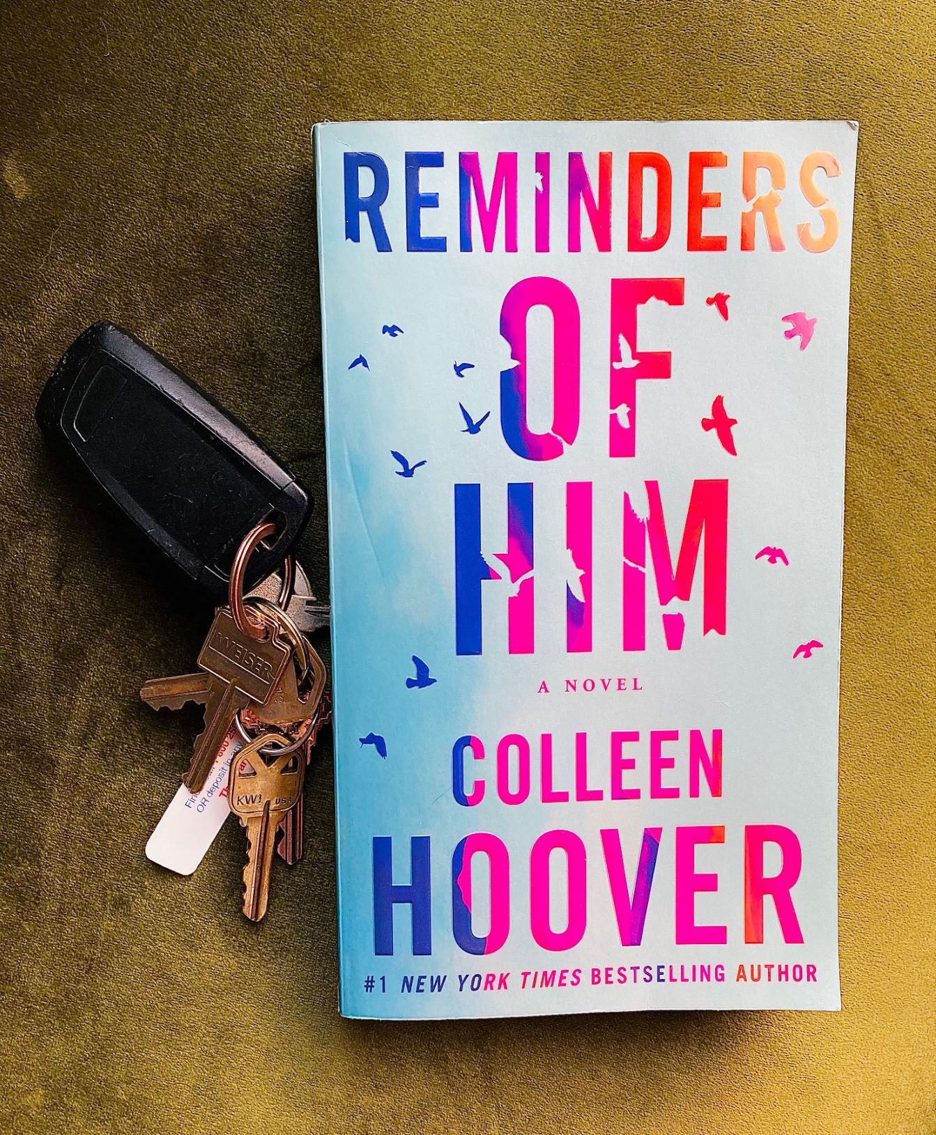Reminders of Him by Colleen Hoover book with keys behind it