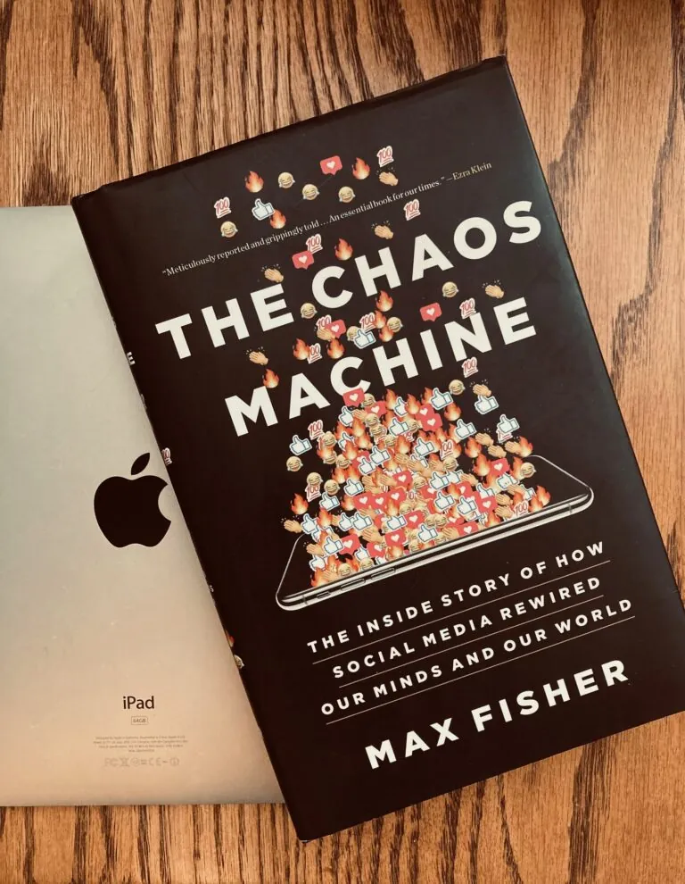 The Chaos Machine by Max Fisher book laying on top of an IPad