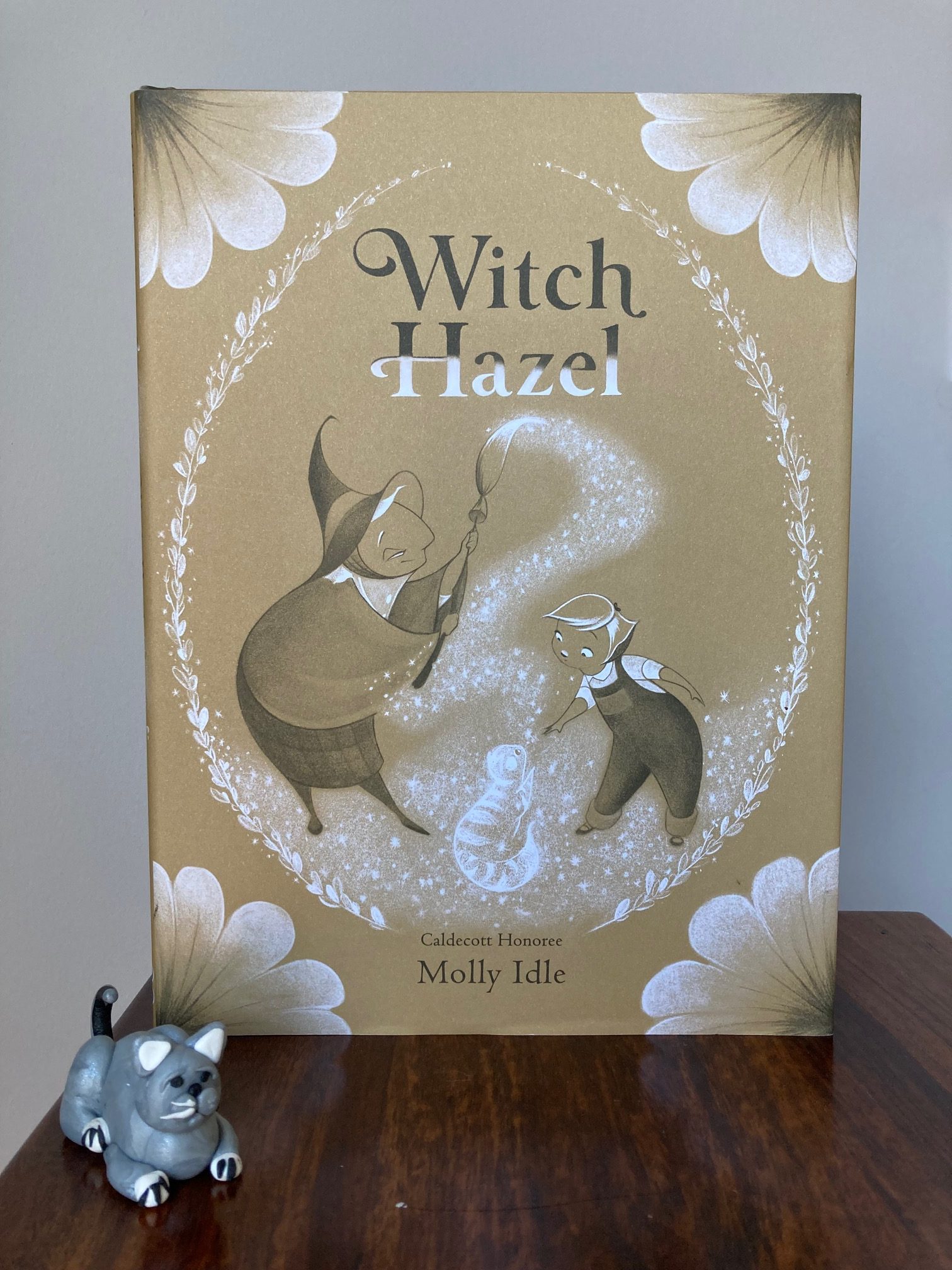 picture book Witch Hazel by Molly Idle, with a small grey fimo cat beside the book