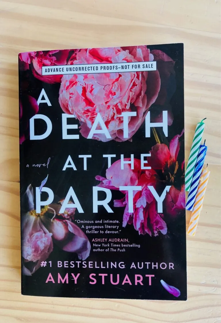 A Death at the Party by Amy Stuart book with three birthday candles beside it