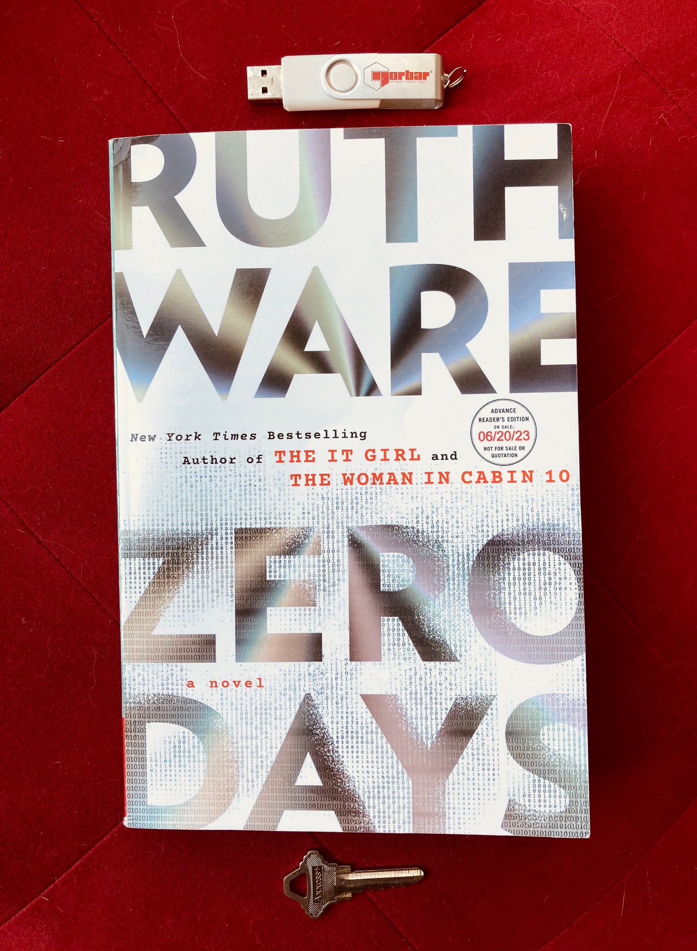Zero Days by Ruth Ware book, pictured with a USB key and a door key on a red background