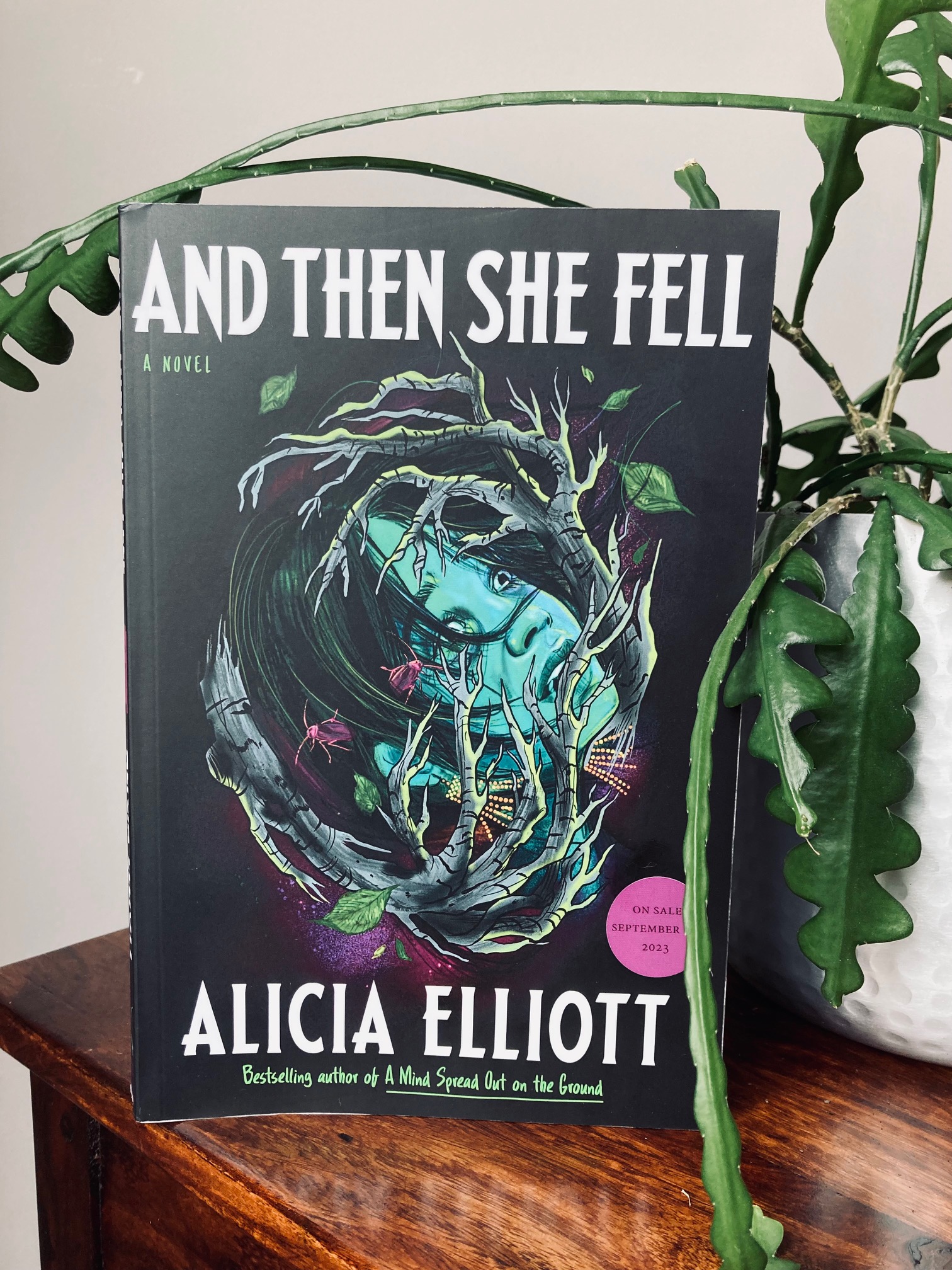 And Then She Fell by Alicia Elliott book surrounded by creeping plants